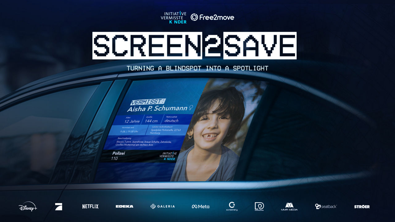 A car window displays a digital missing child alert featuring a smiling girl named Aisha P. Schumann, age 12, with her photo and descriptive details, as part of the 'SCREEN2SAVE' campaign by Initiative Vermisste Kinder and Free2move, aimed at raising awareness for missing children
