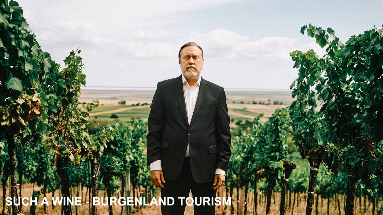 A man standing in the middle of a wineyard looking directly into the camera